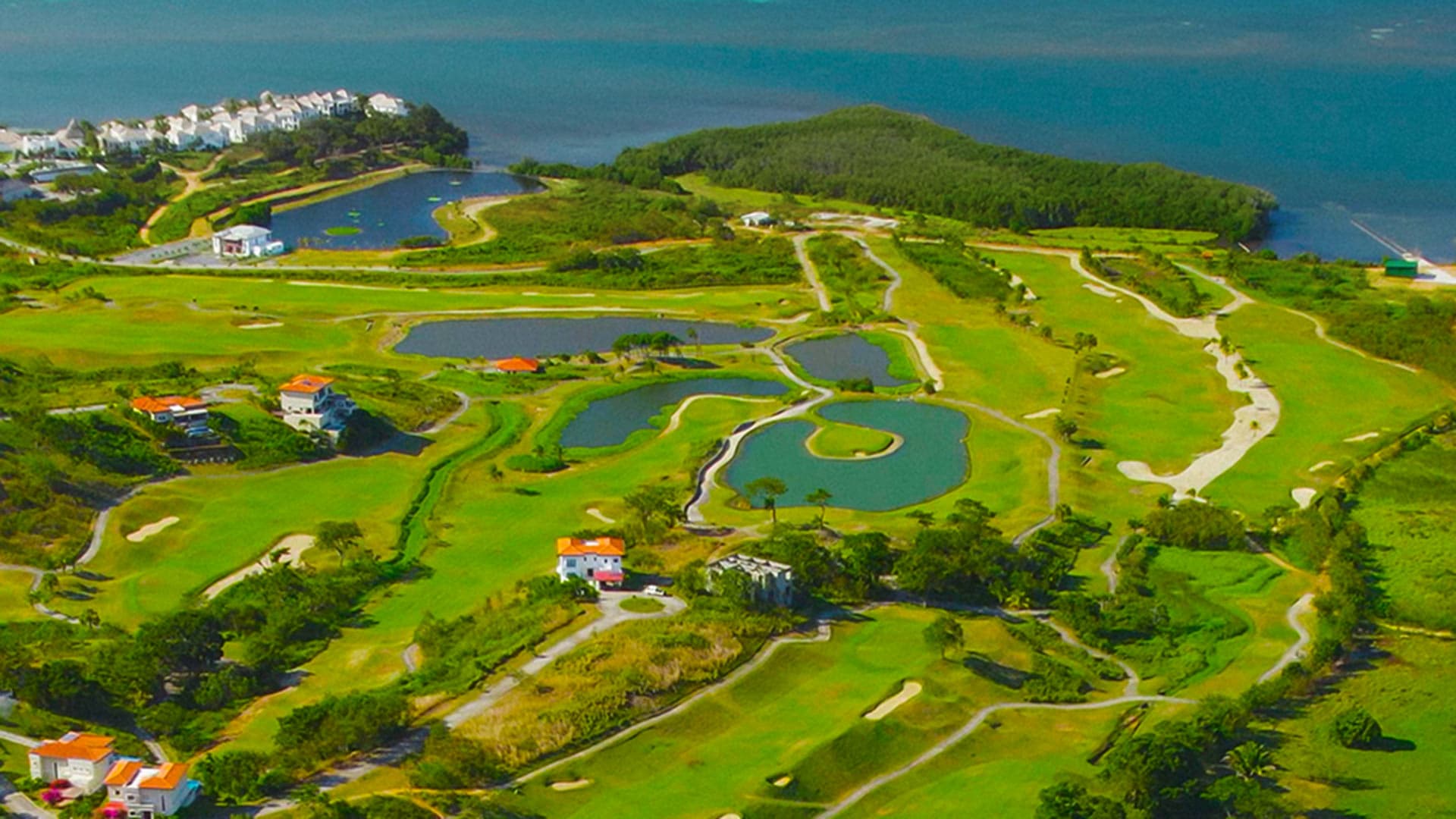 Apartamento moderno frente al mar con área de estar de planta abierta que incluye una cocina blanca totalmente equipada, elegante juego de comedor y cómodo sofá gris. Grandes ventanales ofrecen impresionantes vistas al océano, mientras que la decoración de temática costera y un balcón privado realzan el ambiente de playa. Ideal para alquileres vacacionales de lujo o vida costera contemporánea.